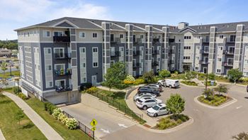 An aerial view of an apartment complex with cars parked in a parking lot
